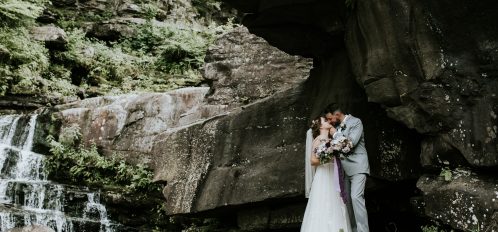 bride and groom kiss at the falls